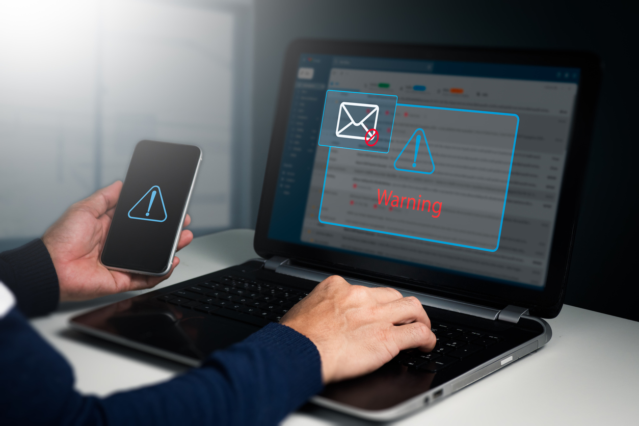 A businessman sees a caution window while working on a laptop at home. network security concept, phishing email warning pop-ups, and spam email.